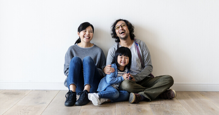 A happy family of three sitting at home