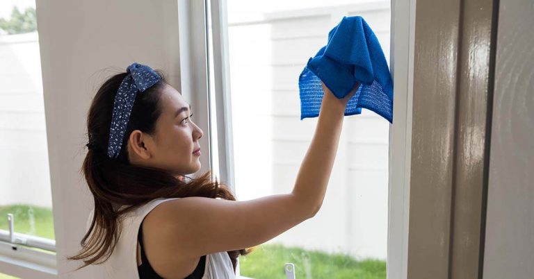 A domestic helper cleaning the window