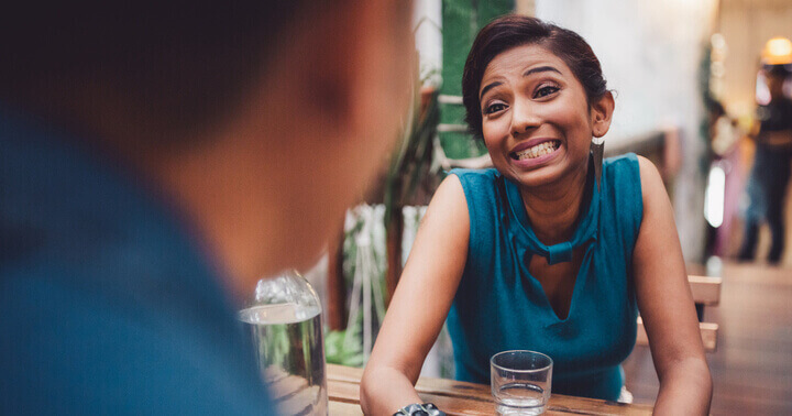 A lady with an animated expression, chatting in a cafe