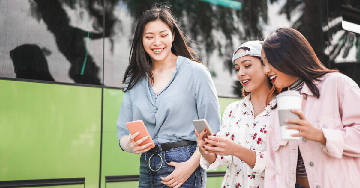 A group of young ladies using their mobile phones, trying to stay connected while abroad