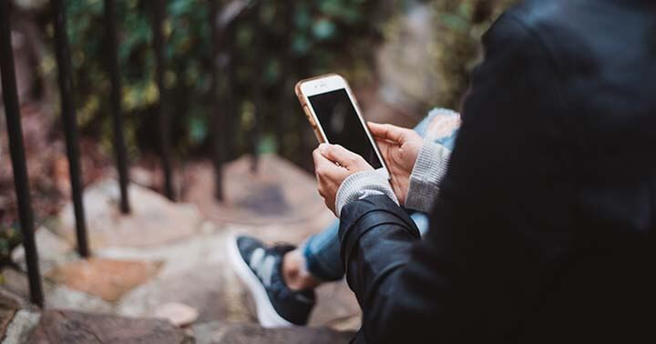 A man in suits using a mobile phone in the outdoors