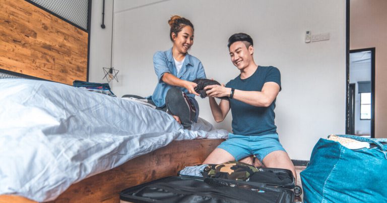 Couple packing for their travel with open luggage