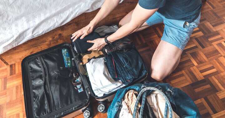 A man packing a luggage in a room