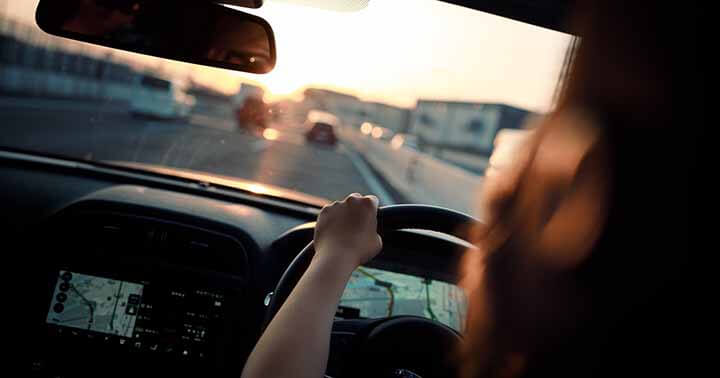 A driver on the road during sunset