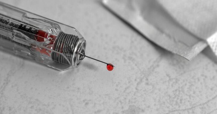 a needle drawing blood 