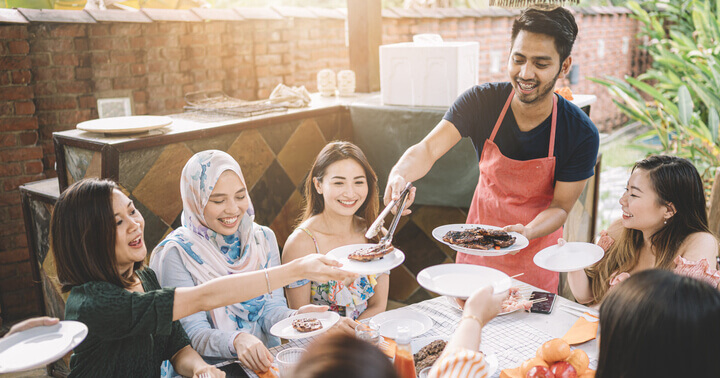 A group of friends at a BBQ enjoying charred food