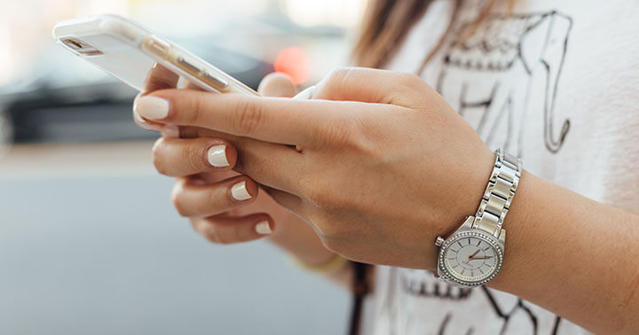 A lady holding a phone and texting