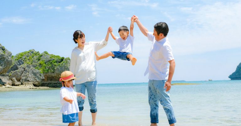 Parents and children playing at the beach on a family travel