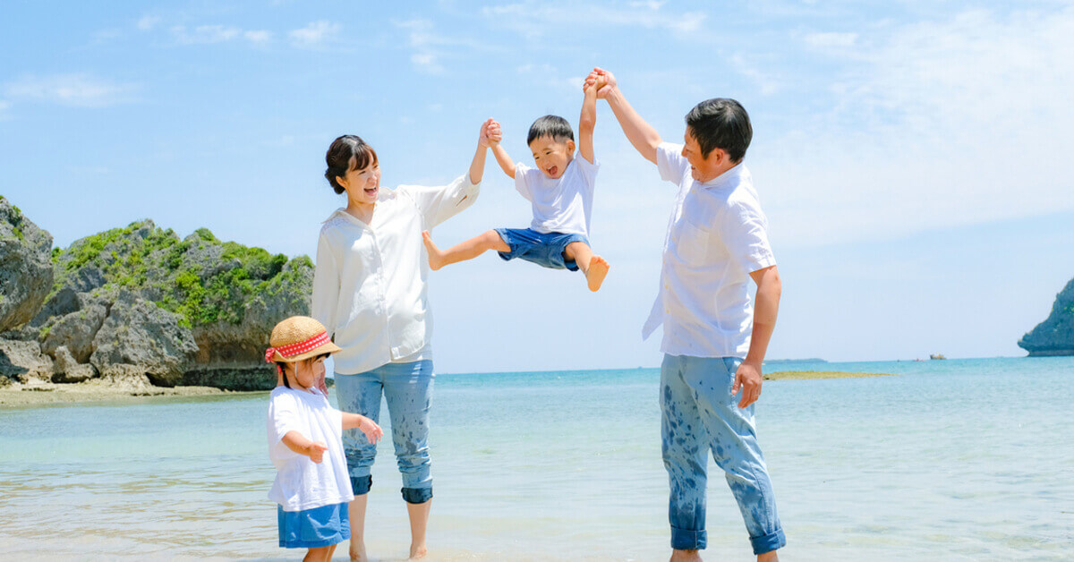 Parents and children playing at the beach on a family travel