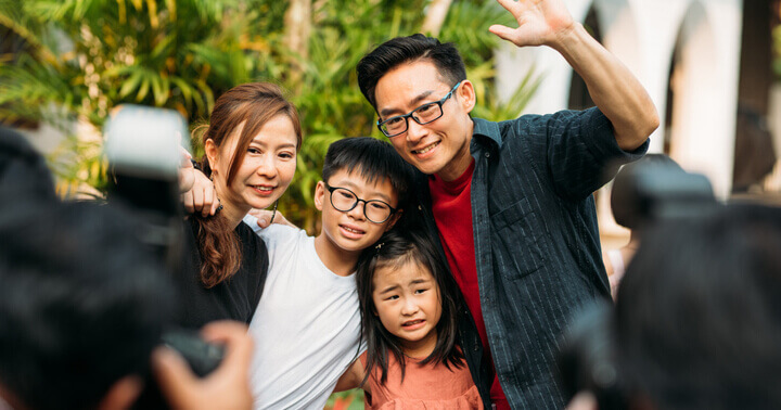 A family being photographed by many photographers