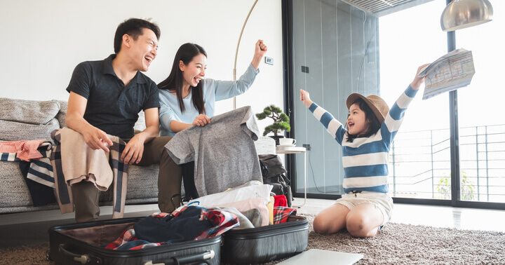 Excited parents and child preparing their luggage for a family travel