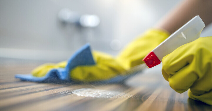 An individual wiping a surface with disinfectant, one of the most vital healtcare items to have during times of flu infection