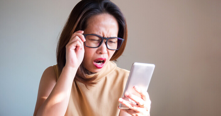 A confused woman staring at her phone unable to believe what she is reading about healthcare items