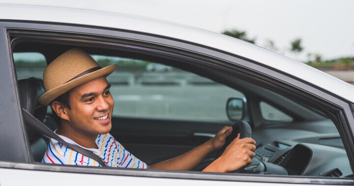 A man looking excited for a drive after buying a car