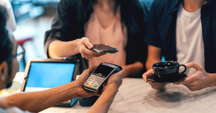 A couple using e-wallets for money management purposes when purchasing coffee