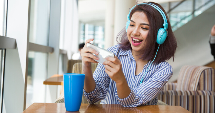 Millennial playing online games and streaming online music using smartphone