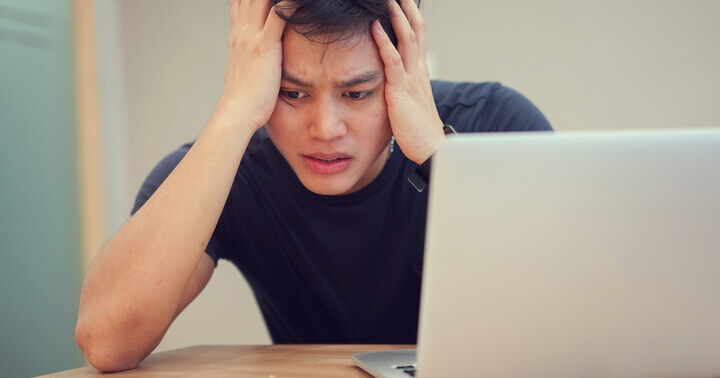 A man being emotionally influenced in a love scam sitting in front of his laptop