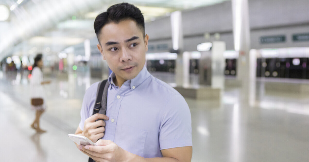 A man with a phone at the train station