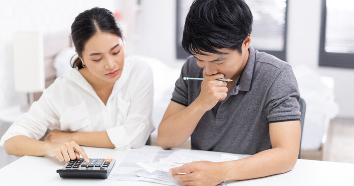A couple calculating budget for the different types of life insurance that they are considering to get