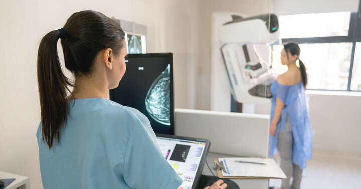 A woman doing a mammogram to detect the presence of breast cancer