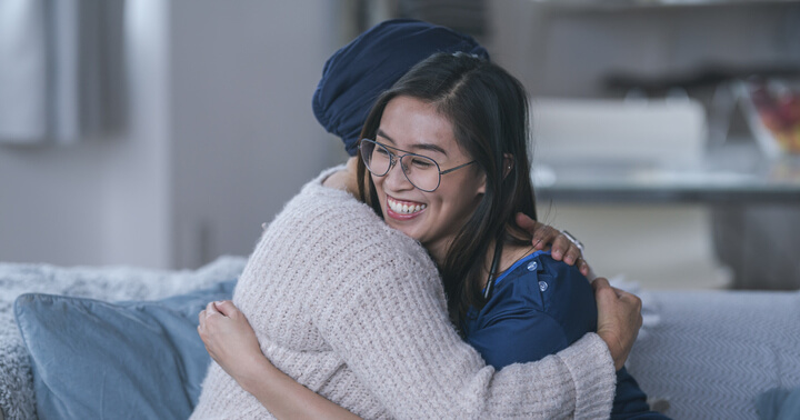 A female doctor happily embracing a female patient