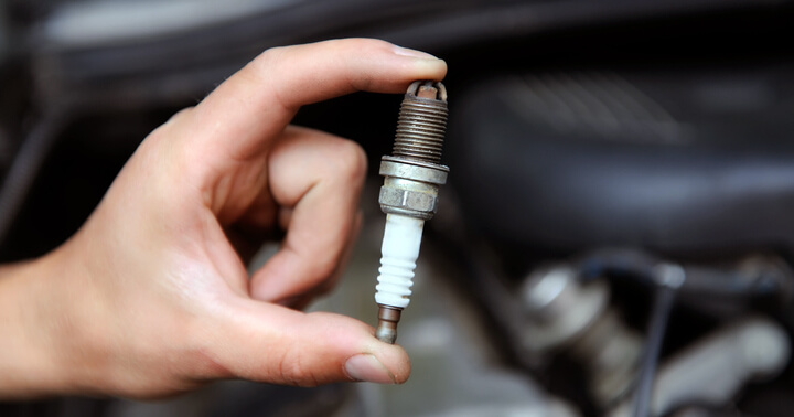 A person holding up a spark plug