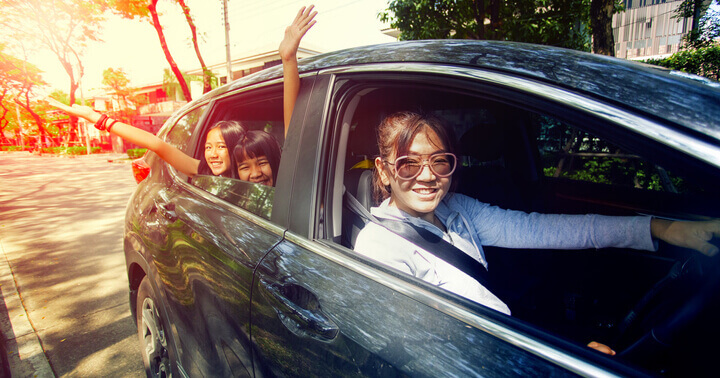 A woman and her two children in a family car which uses RON95 as the preferred petrol type