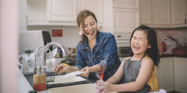 Mother and daughter having fun using life hacks in the kitchen
