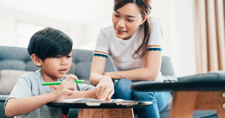 A mother helping her son study at home.