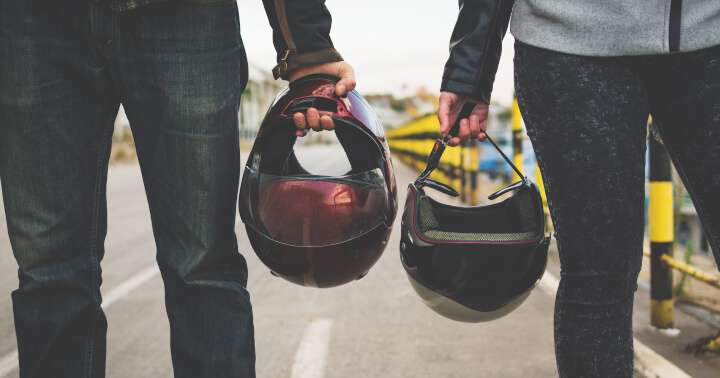 Couple holding helmets
