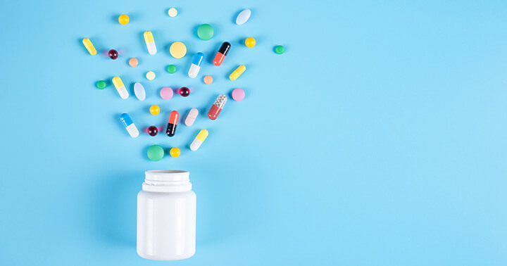 Happy pills against bright blue background, signifying hope