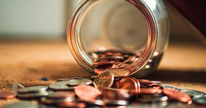 Coins falling out from jar on the ground