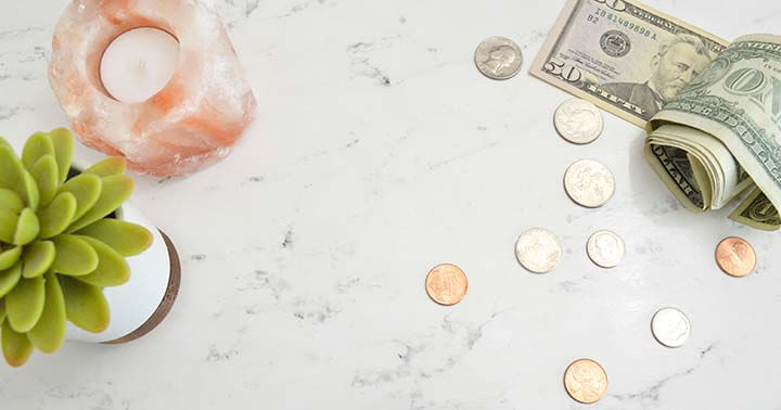 Money, candle and trinkets on a table top