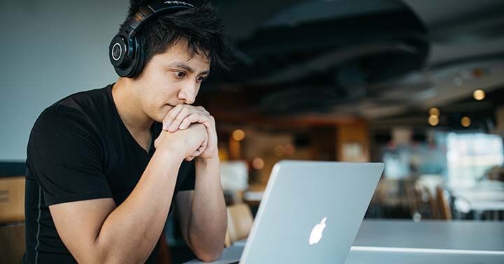 A man looking keenly at his laptop