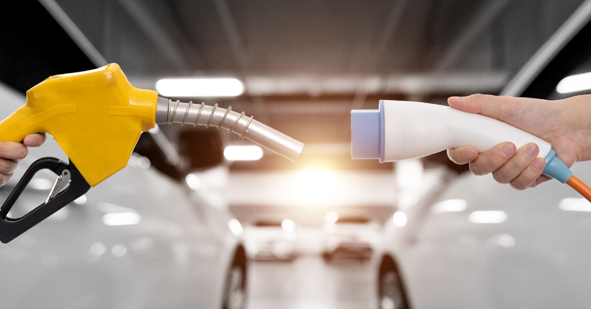 hands-holding-electric-plug-and-gasoline-nozzle