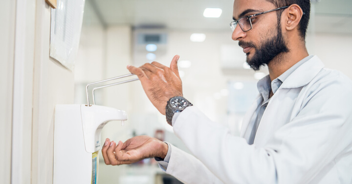 A medical staff using hand sanitizer
