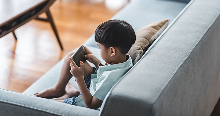 Chinese boy using smart phone in the living room