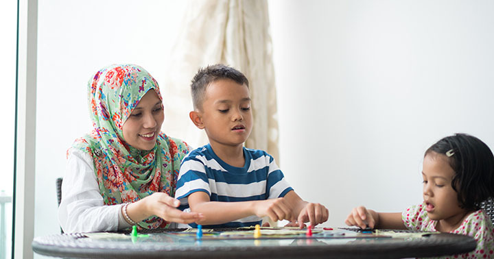 Mom playing a board game with her kids