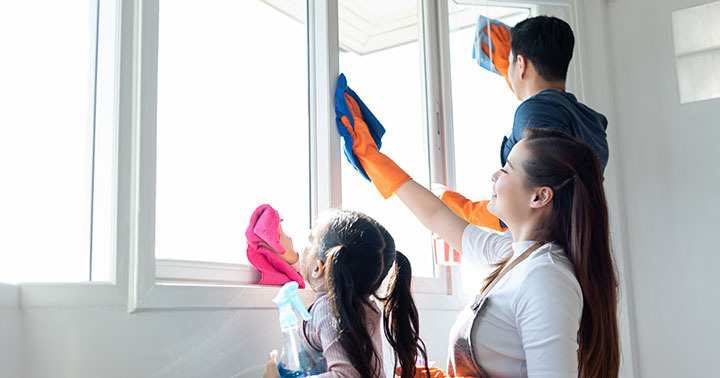 Asian Family helping cleaning House together. Dad, Mom and daughter are wiping dust on windowsill. Having fun on Holidays.