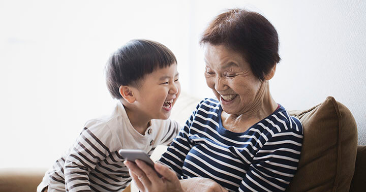 Happy grandmother and toddler grandson at home