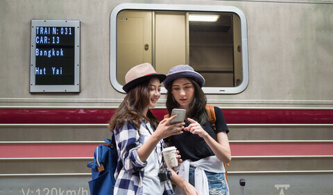 Female travellers in front of an immobile train