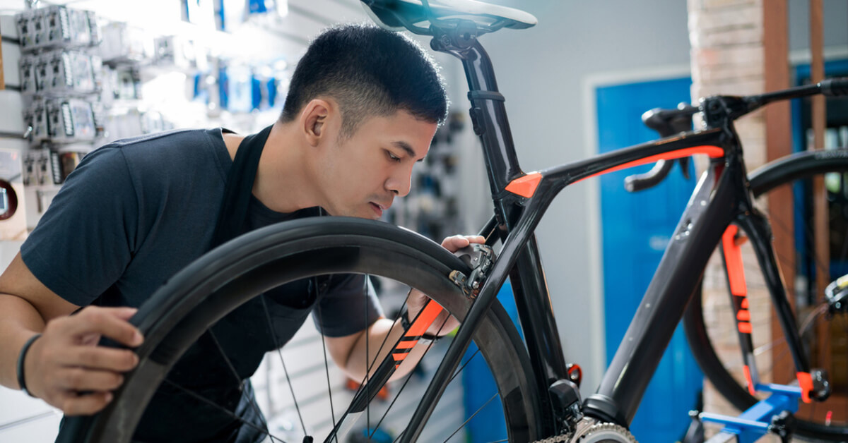 A bicycle technician looking at different bicycle types