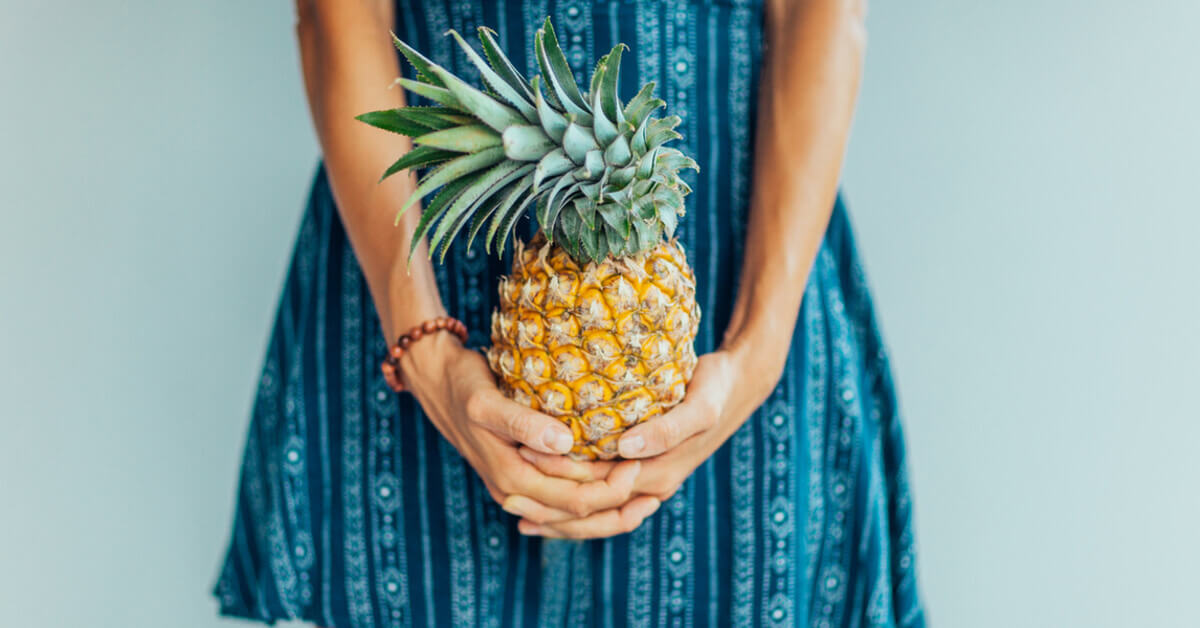 A lady holding a pineapple to be rolled in a new home for luck