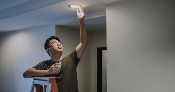 A man using LED light bulb to save electricity