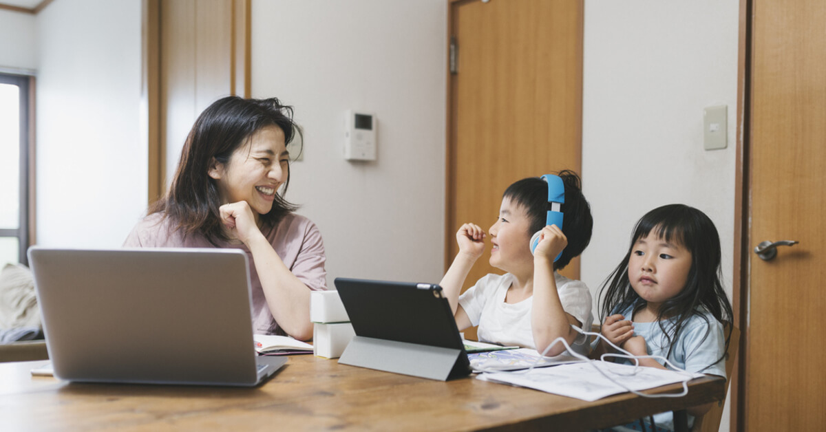 A mother staying productive at home while working wirelessly and keeping her children company