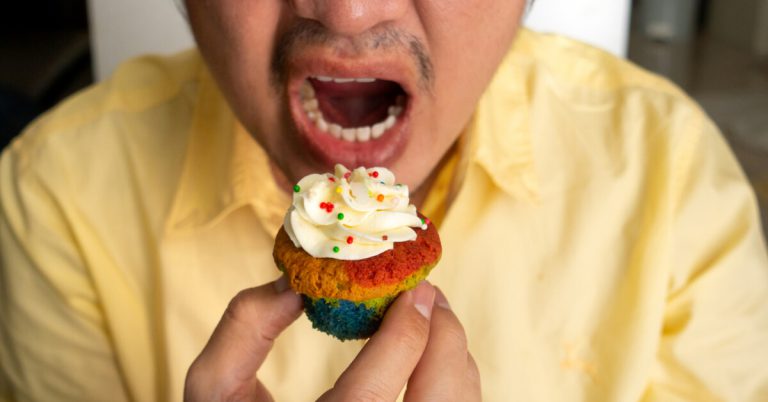 Man on the verge of taking a bite of the sweet-looking cupcake