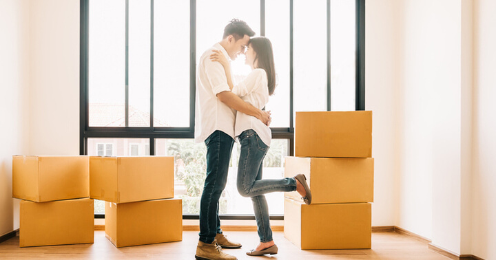 New homeowners in their home with unopened boxes