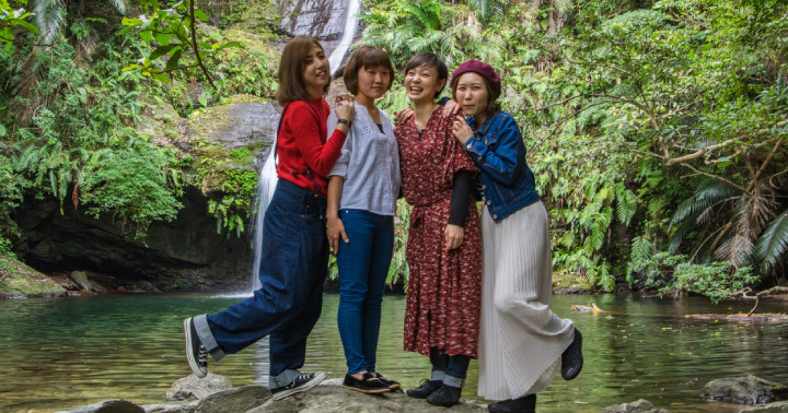 A group of friends posing in front of waterfall at Batam