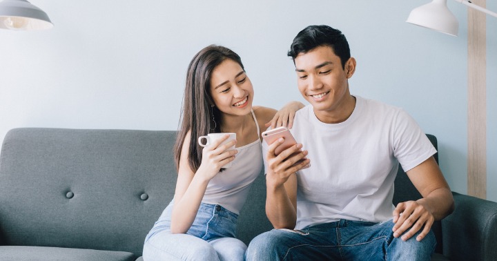 Young couple at home with mobile devices