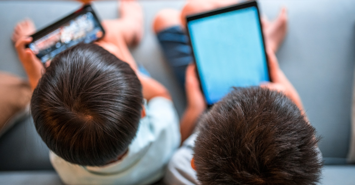 boys-using-digital-devices-sitting-on-a-sofa
